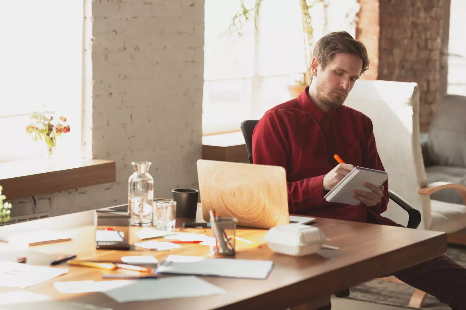 a man sitting at a table writing on a notepad