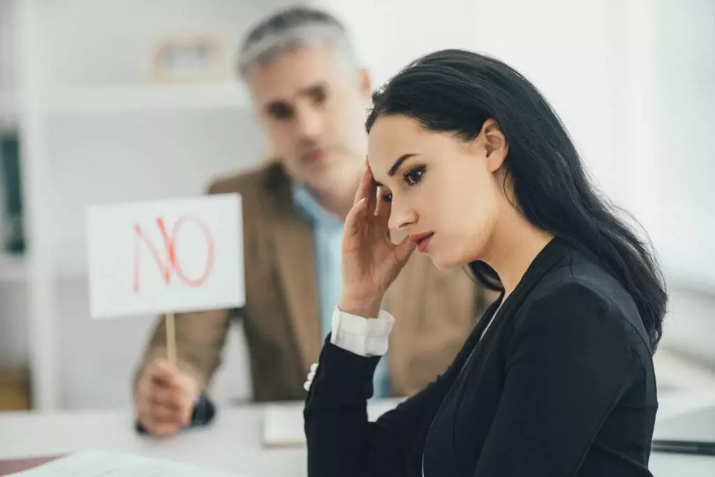 a woman sitting at a table with a No Sign