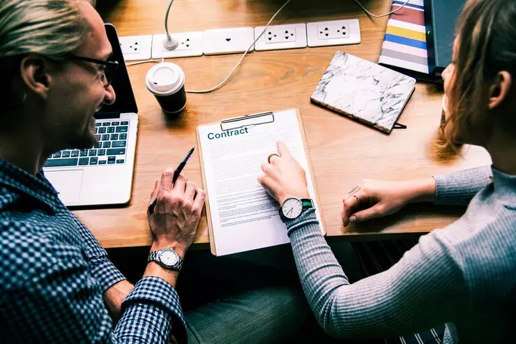 Businesspeople reviewing contract, discussing Australian Financial Services Licence (AFSL) application.
