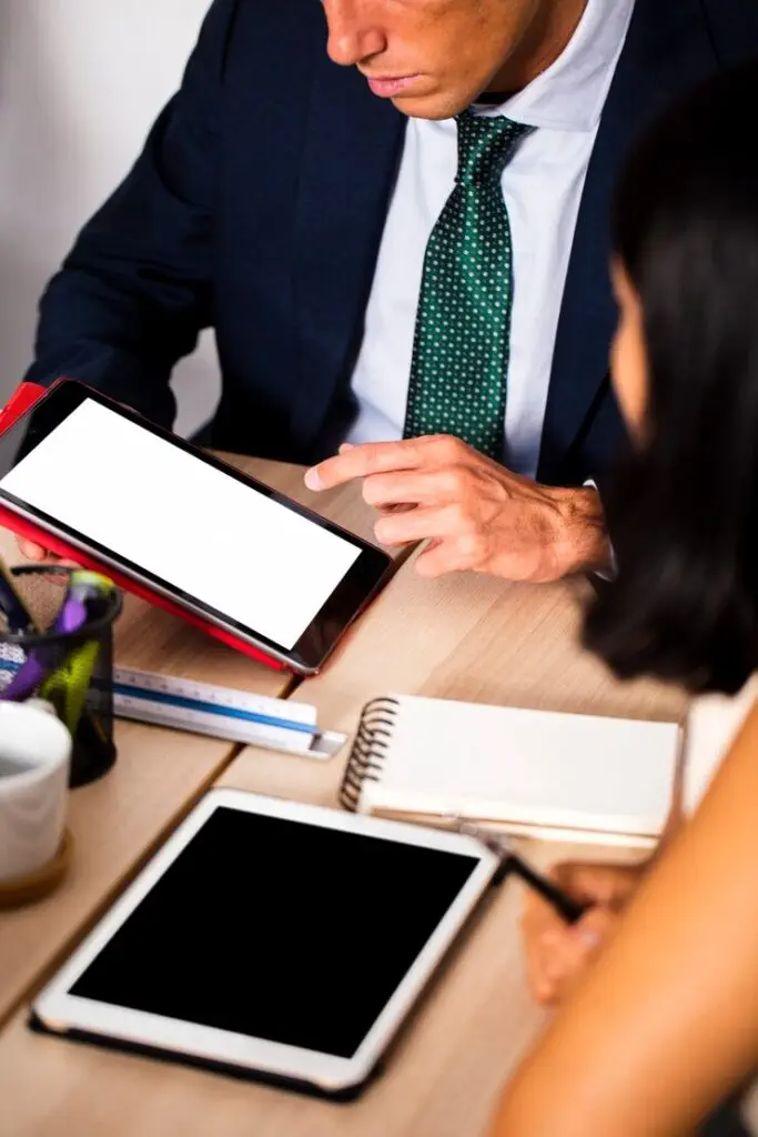 Businesspeople reviewing documents on tablets.
