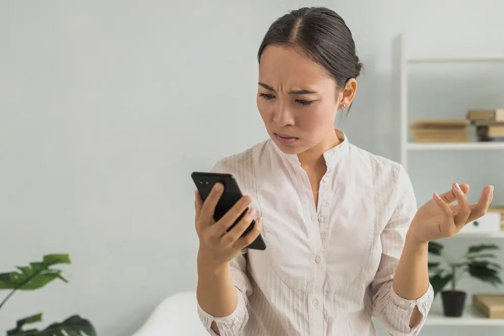 Frustrated woman looking at her phone after receiving her AFS license.