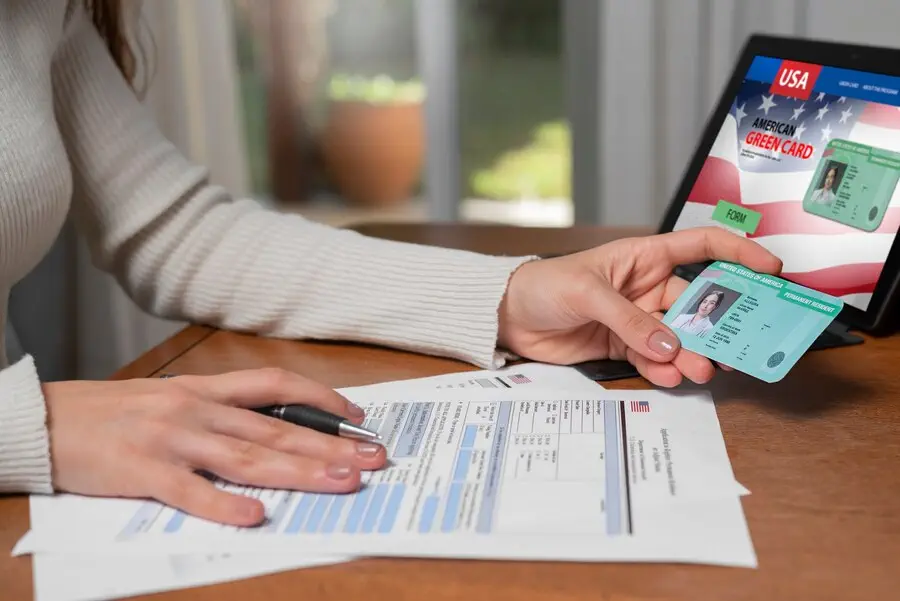 Person completing a green card application form.