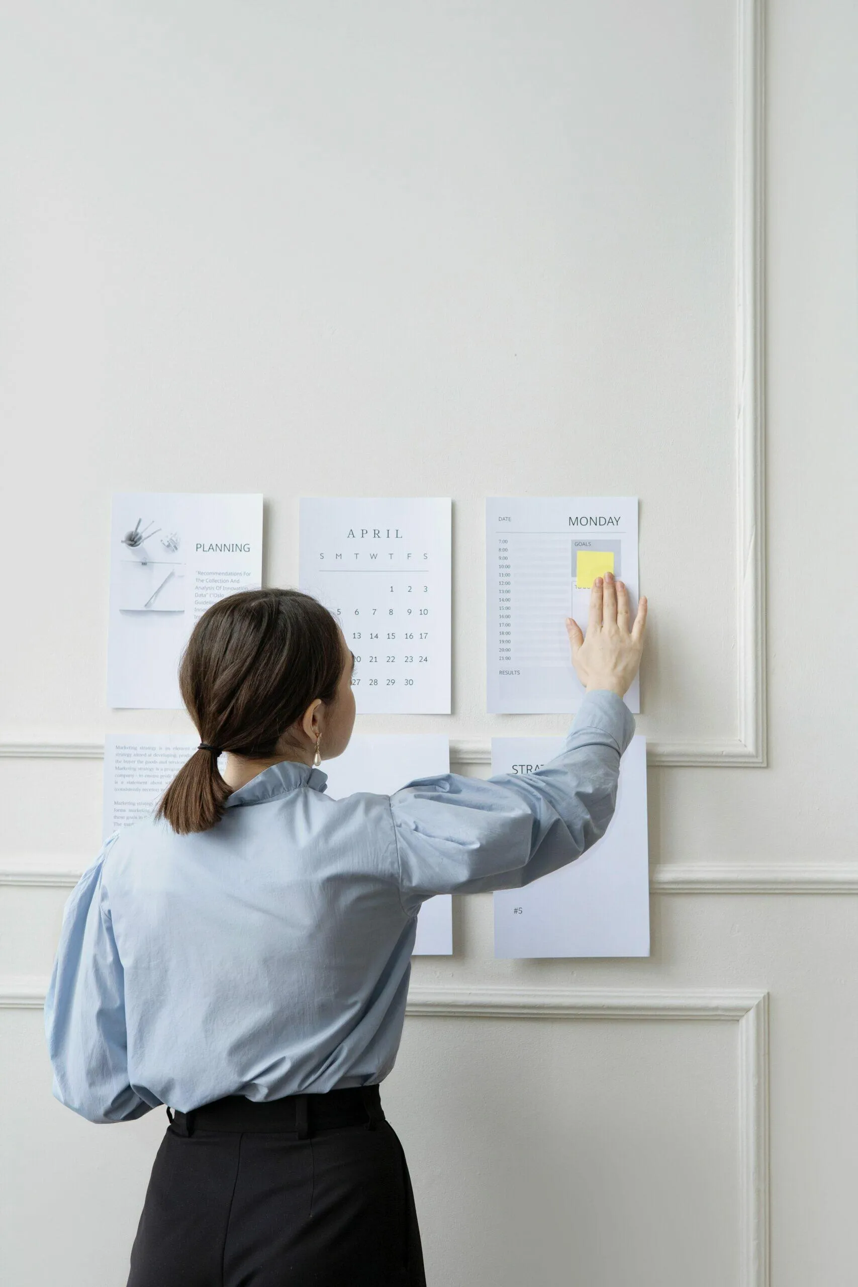 Woman organizing April calendar and schedule, planning tasks for AFSL compliance.