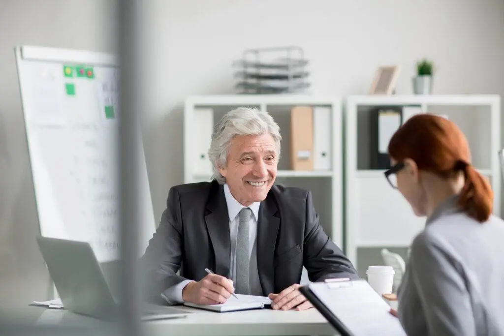 Senior financial advisor meeting with a client, discussing wholesale vs retail clients in Australian financial services.