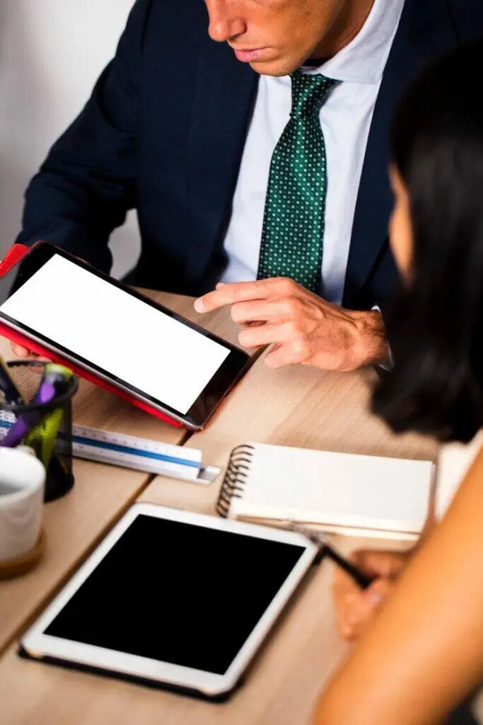 Businesspeople reviewing documents on tablets.